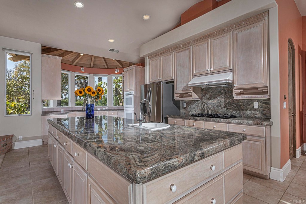 6944 Rancho Cielo Rancho Santa Fe, CA 92067 - Photo 9 of 37 a kitchen with stainless steel appliances granite countertop a sink a stove and a refrigerator