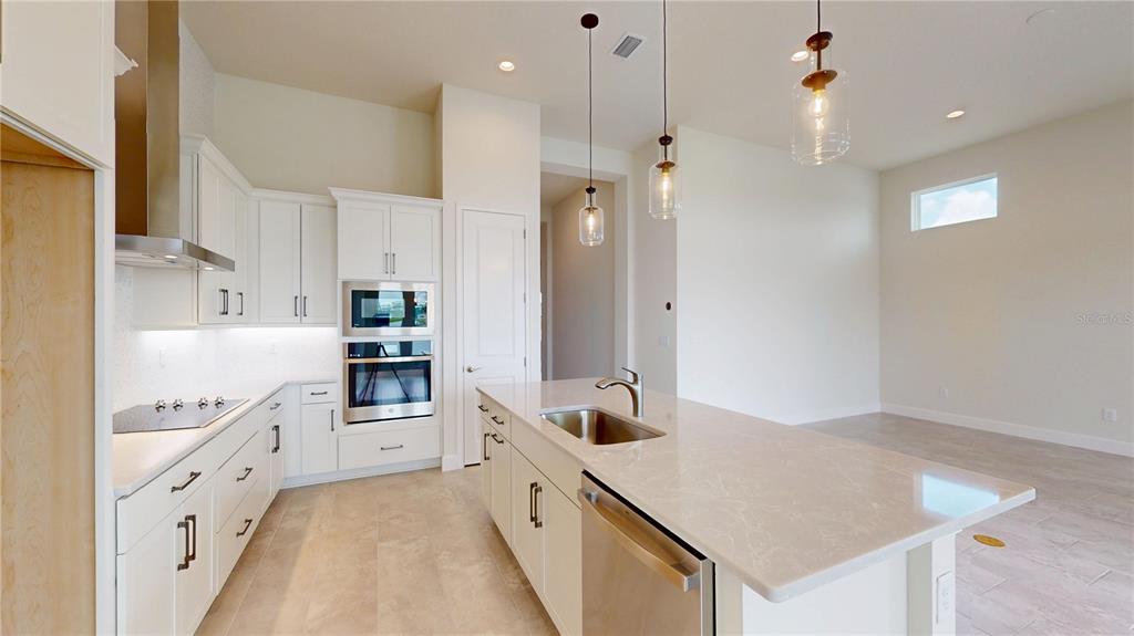 247 Azure Mist Way Daytona Beach, FL 32124 - Photo 13 of 40 a large kitchen with stainless steel appliances a refrigerator and a stove top oven