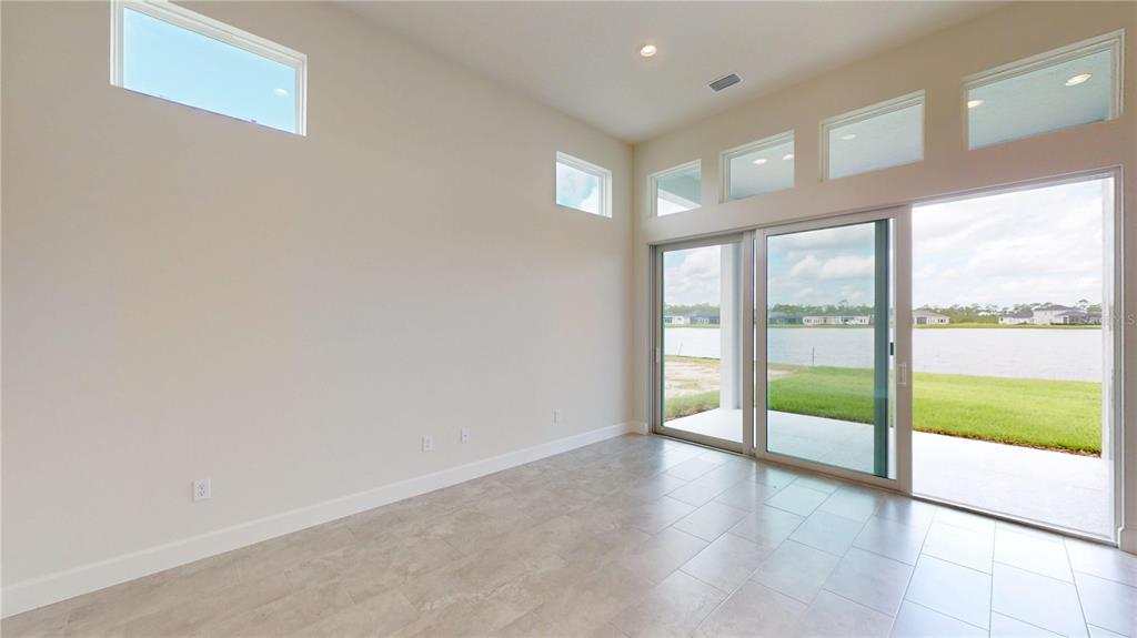 247 Azure Mist Way Daytona Beach, FL 32124 - Photo 16 of 40 a view of an empty room with wooden floor and a large window