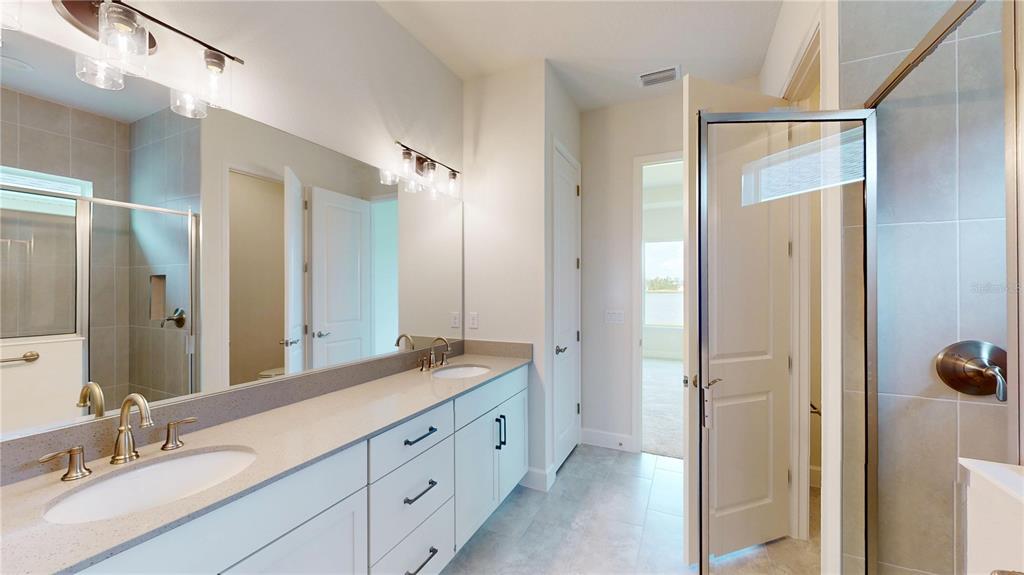 247 Azure Mist Way Daytona Beach, FL 32124 - Photo 24 of 40 a spacious bathroom with a double vanity sink a mirror and a shower