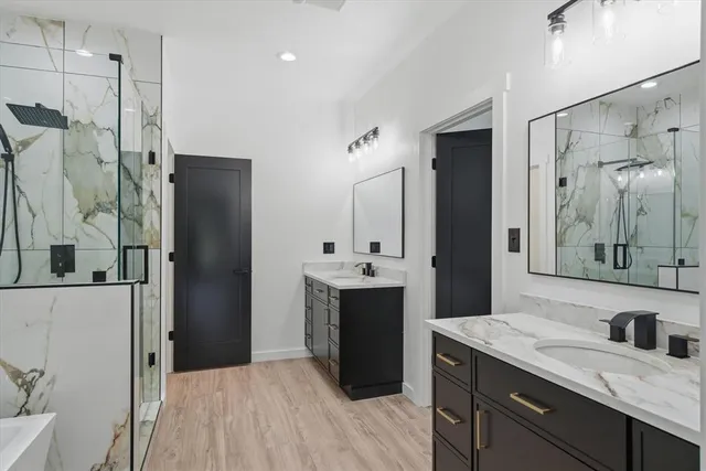 a spacious bathroom with a granite countertop sink mirror and shower