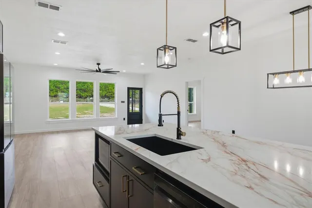 a view of a kitchen with a sink stainless steel appliances and cabinets
