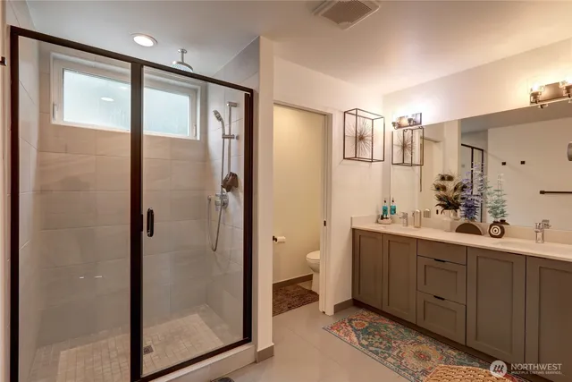 a bathroom with a double vanity sink mirror and shower