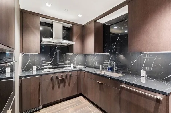 a kitchen with kitchen island granite countertop a sink stainless steel appliances and cabinets