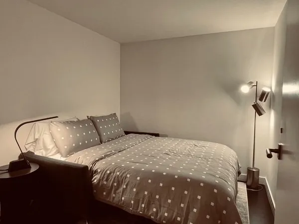 a bedroom with a bed and a night stand