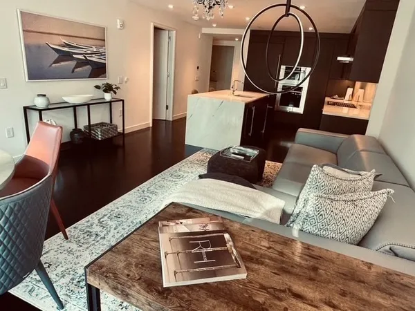 a living room with furniture rug and kitchen view