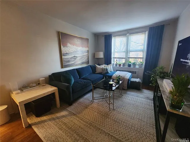 a living room with furniture a flat screen tv and a large window