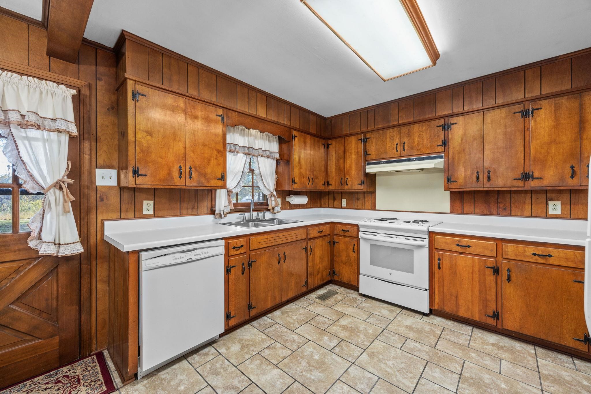 213 Forrest School Road Corinth, MS 38834 - Photo 11 of 40 Kitchen with white appliances, plenty of natural light, wood walls, and sink