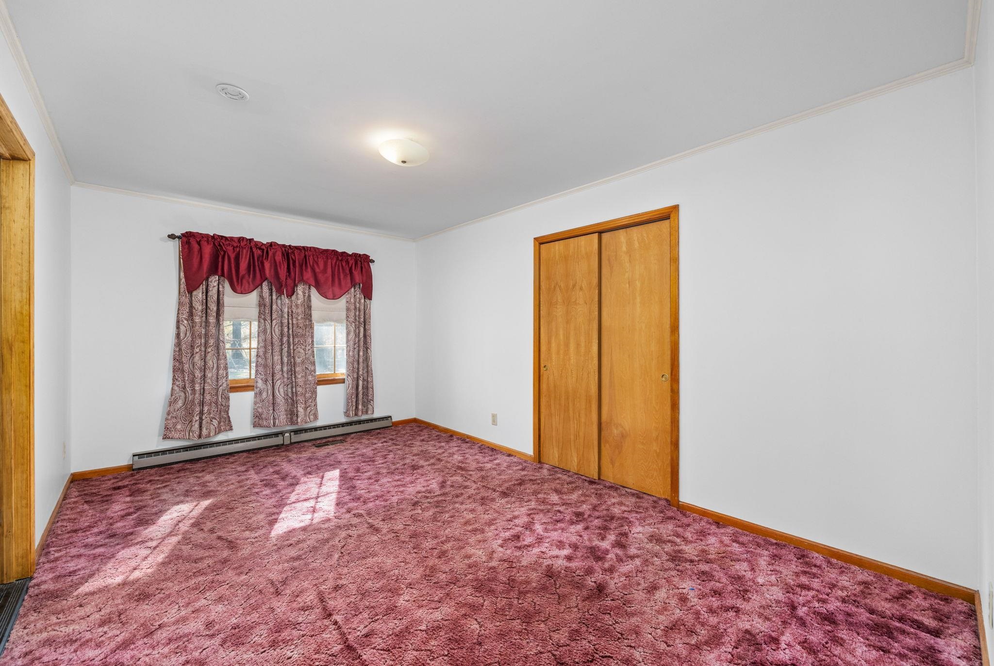 213 Forrest School Road Corinth, MS 38834 - Photo 13 of 40 Unfurnished bedroom with baseboard heating, crown molding, a closet, and carpet