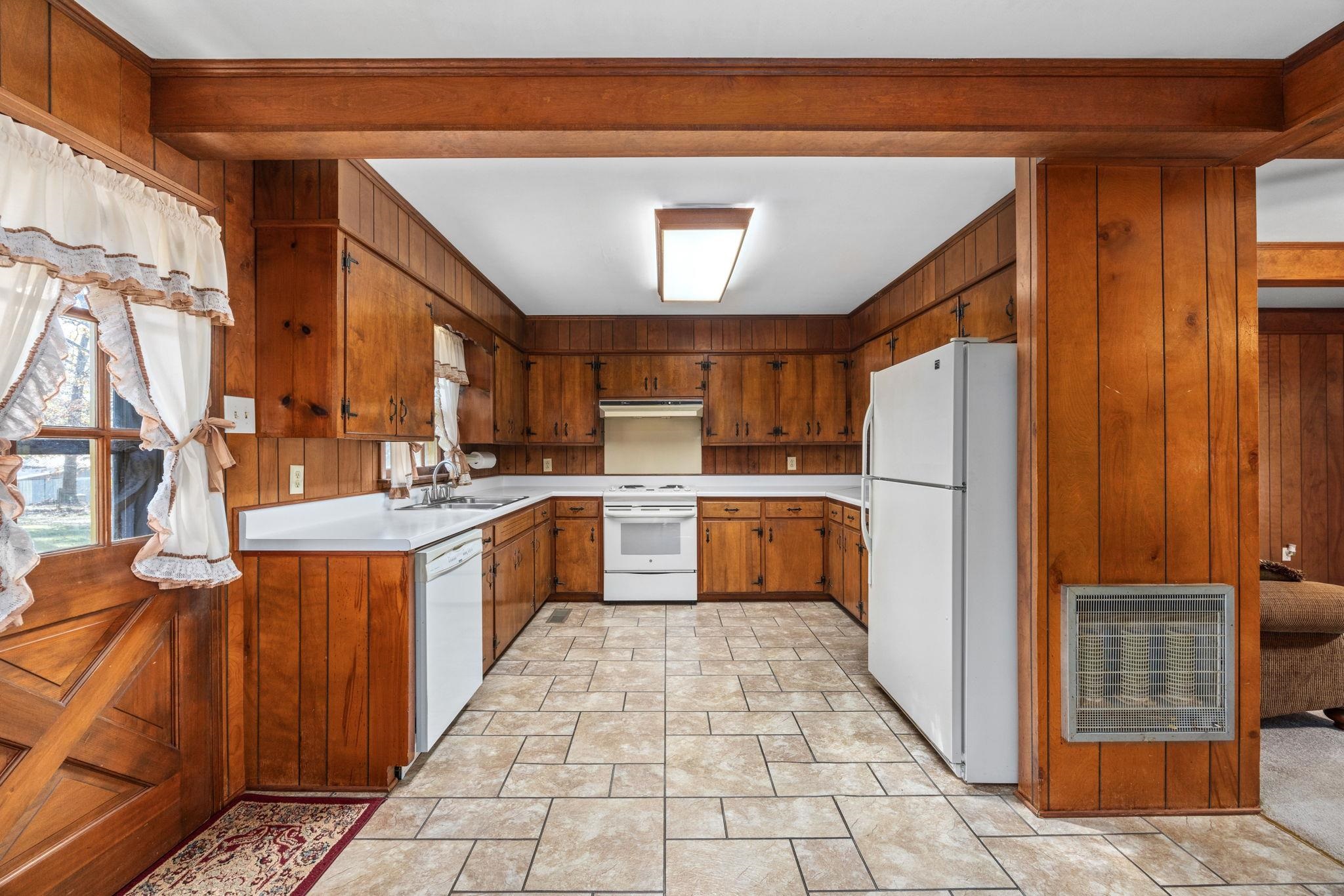 213 Forrest School Road Corinth, MS 38834 - Photo 9 of 40 Kitchen featuring wood walls, white appliances, sink, and heating unit