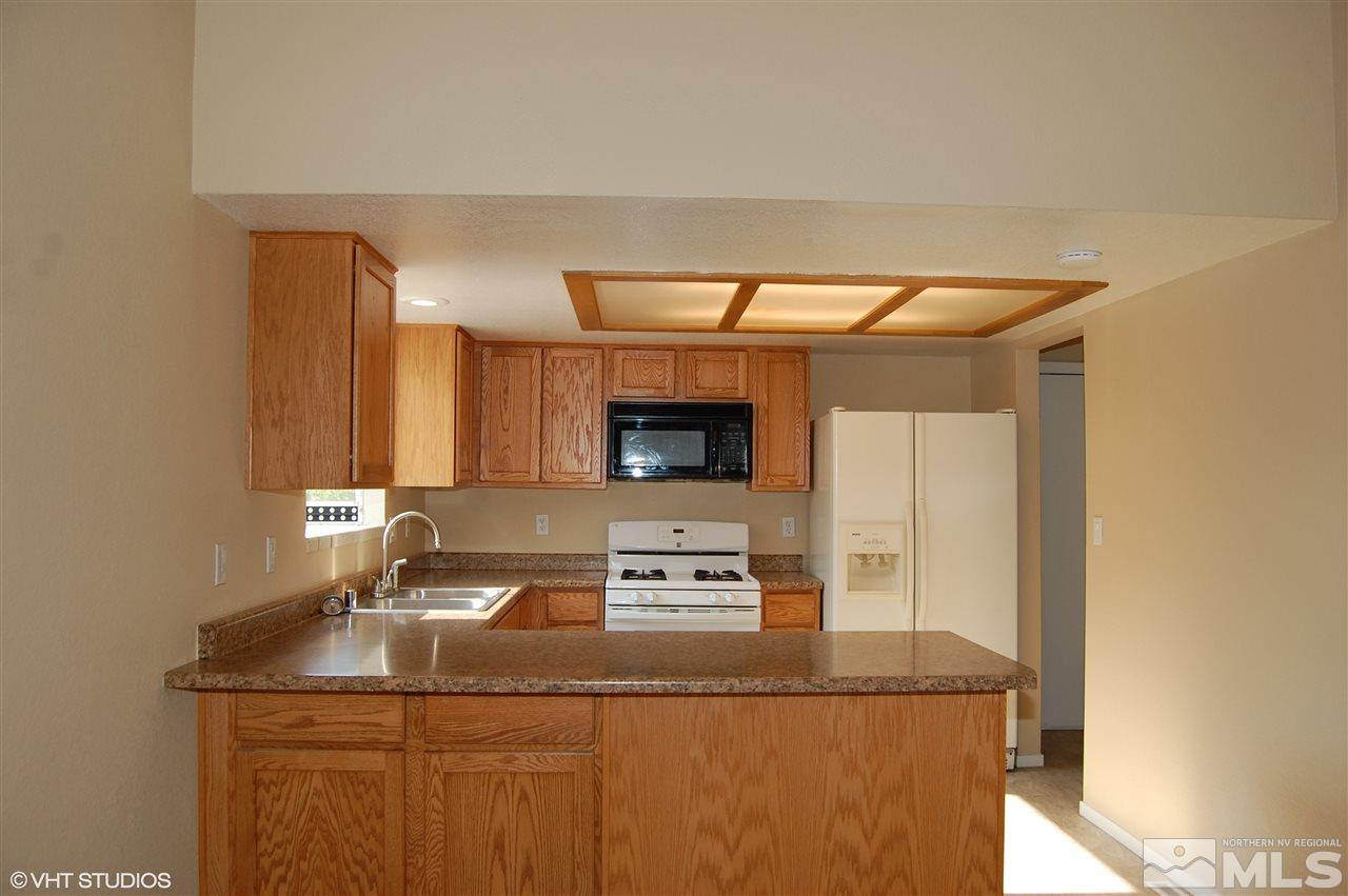 2415 Durango Court Reno, NV 89503 - Photo 7 of 25 a kitchen with granite countertop a sink a stove and a microwave oven