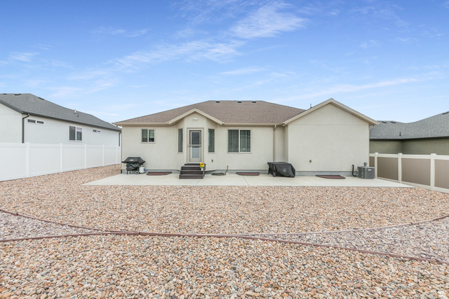 1228 North Providence Way Tooele, UT 84074 - Photo 27 of 28 Rear exterior featuring a neutral stucco facade and a brown shingle roof