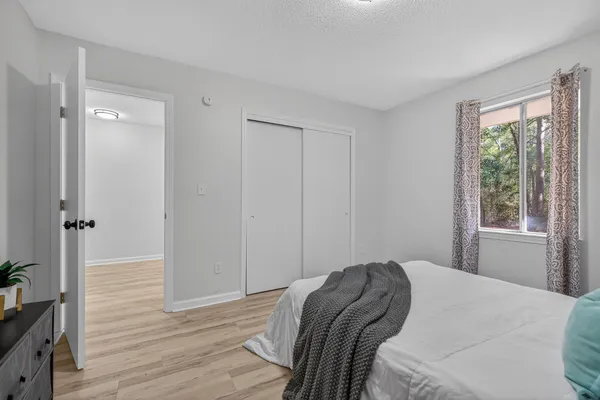 a view of a hallway with wooden floor and closet