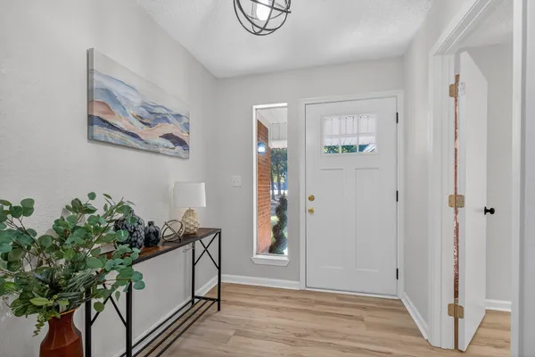 a living room with furniture large window and wooden floor