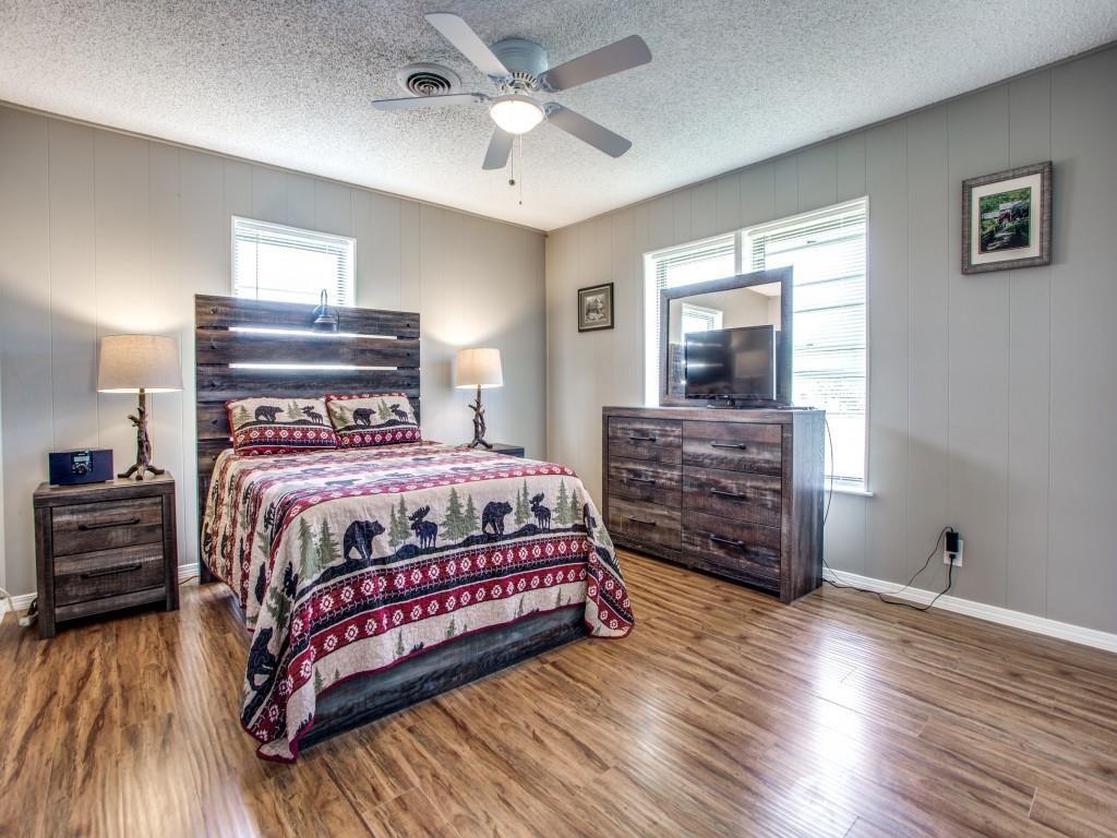 500 North 5th Street Gunter, TX 75058 - Photo 6 of 11 a bedroom with a bed a dresser and wooden floor