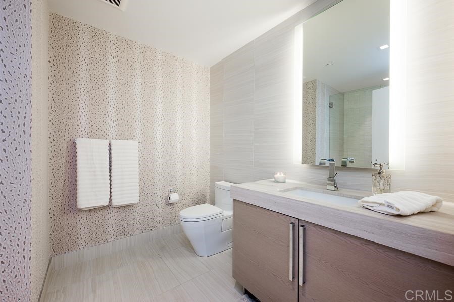 888 West E Street San Diego, CA 92101 - Photo 29 of 30 a bathroom with a granite countertop sink toilet and mirror