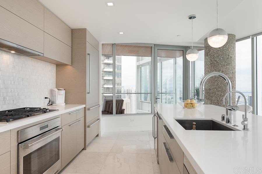 888 West E Street San Diego, CA 92101 - Photo 5 of 30 a kitchen with counter top space a sink stainless steel appliances and cabinets