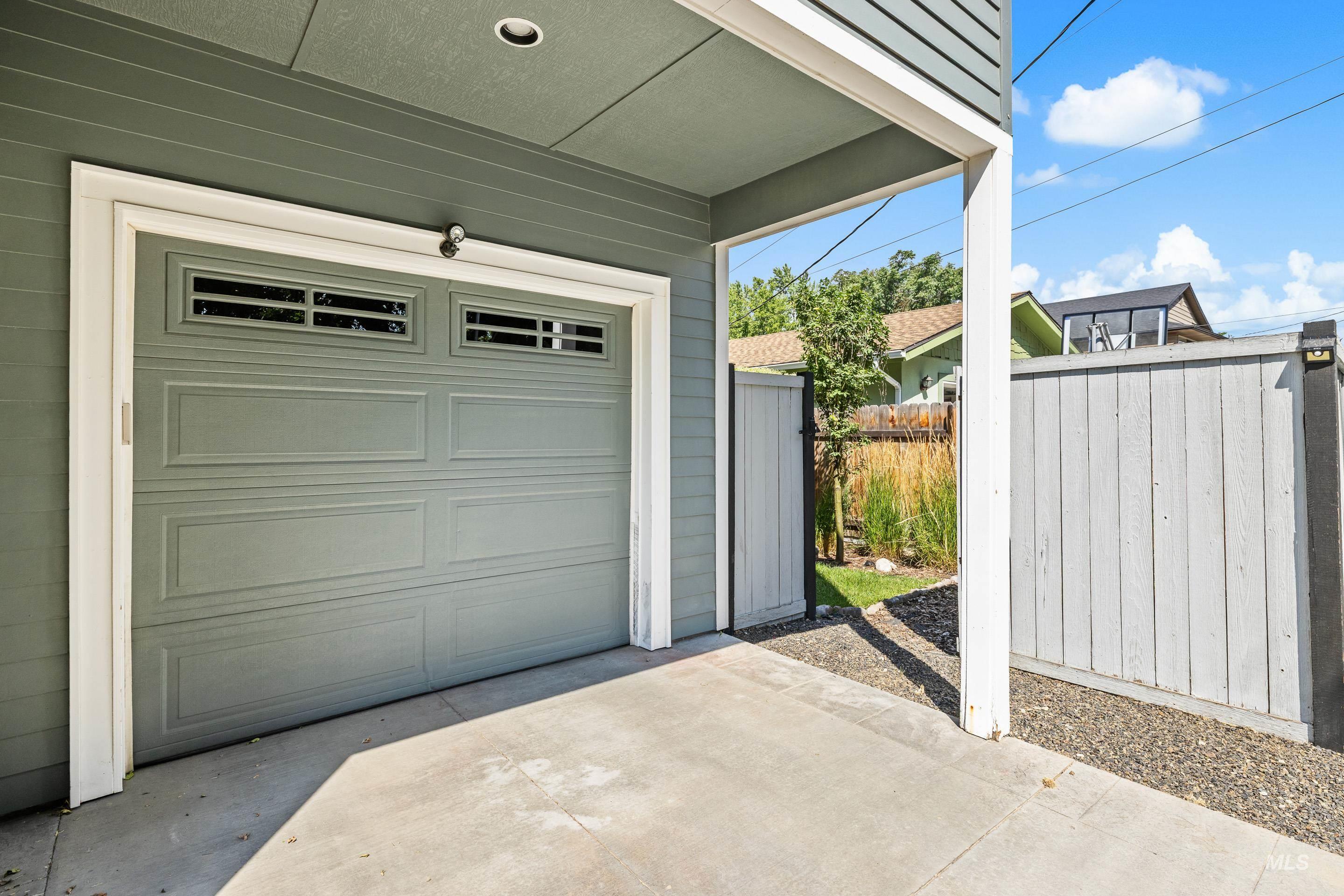 1862 West Ridenbaugh Street Boise, ID 83702 - Photo 39 of 40 Attached garage with upper window panels, concrete driveway, horizontal siding, and a privacy fence