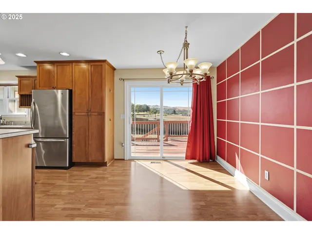 a view of a kitchen with refrigerator and wooden floor