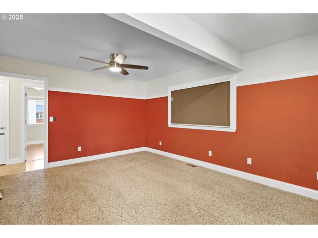 a view of an empty room with a ceiling fan