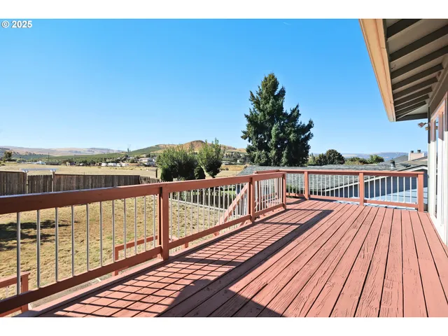 a view of balcony with wooden floor and fence