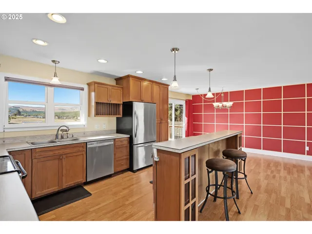 a kitchen with stainless steel appliances a sink a stove a refrigerator and cabinets