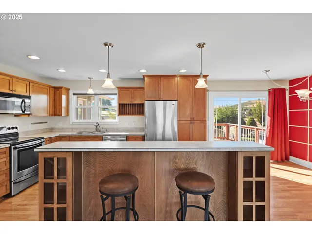 a kitchen with stainless steel appliances granite countertop a sink a stove and a refrigerator