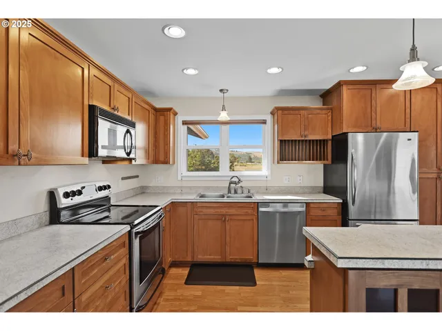 a kitchen with stainless steel appliances granite countertop a sink stove and refrigerator