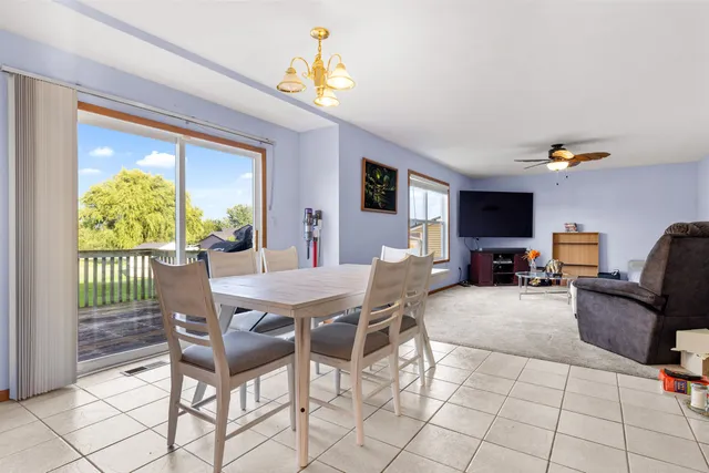 a view of a dining room with furniture a rug and a flat screen tv