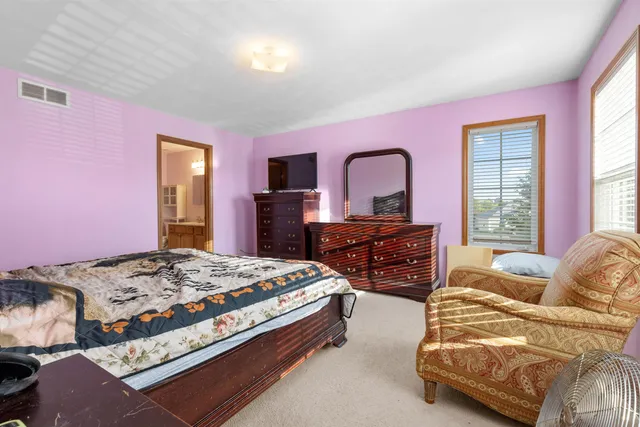 a bedroom with a bed and dresser with mirror