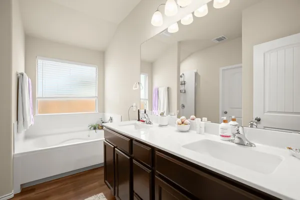 a bedroom with a bed and a flat tv screen on dresser