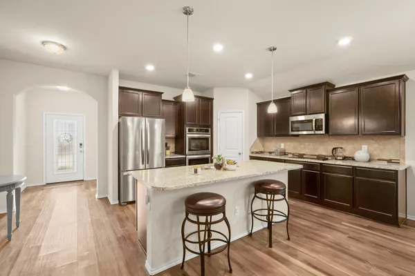 a kitchen with center island table and chairs
