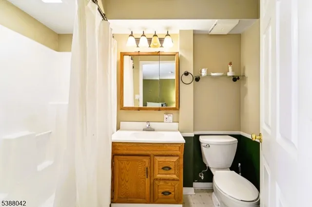 a bathroom with a granite countertop toilet sink and mirror