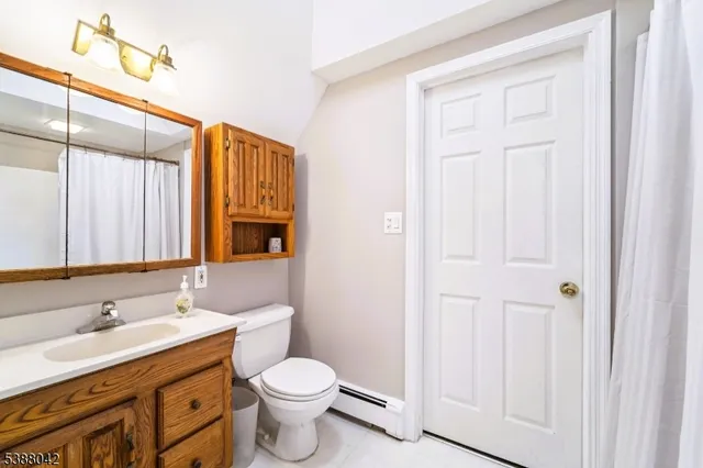 a bathroom with a toilet a sink and a large mirror