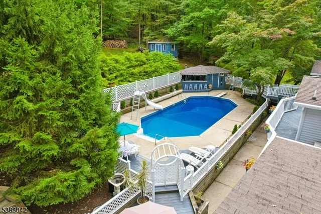 a view of a house with pool and chairs