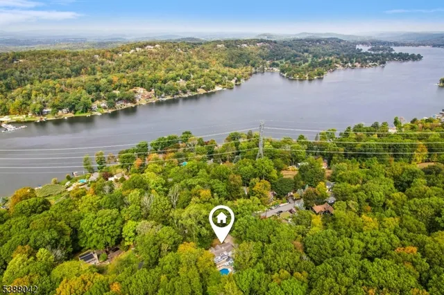 an aerial view of residential houses with outdoor space and lake view