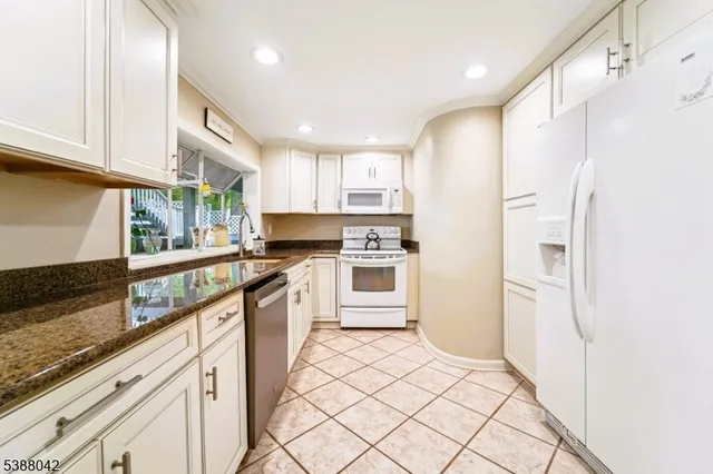 a kitchen with stainless steel appliances a refrigerator sink and cabinets