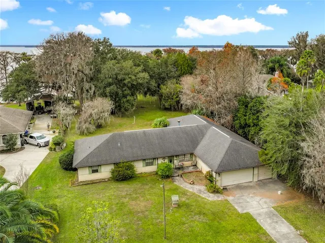 a view of a swimming pool with a patio and a yard
