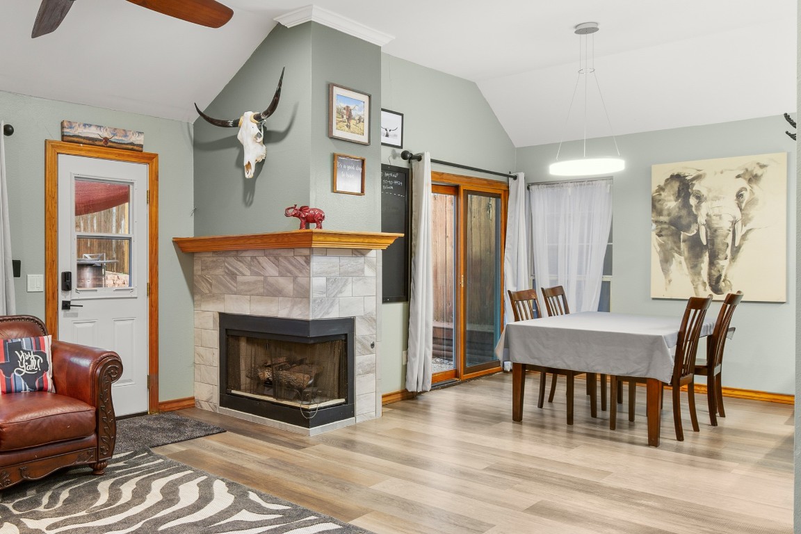 3015 Sunridge Drive Austin, TX 78741 - Photo 10 of 35 Dining space featuring ceiling fan, a fireplace,
vaulted ceiling, wood finished floors, and
baseboards