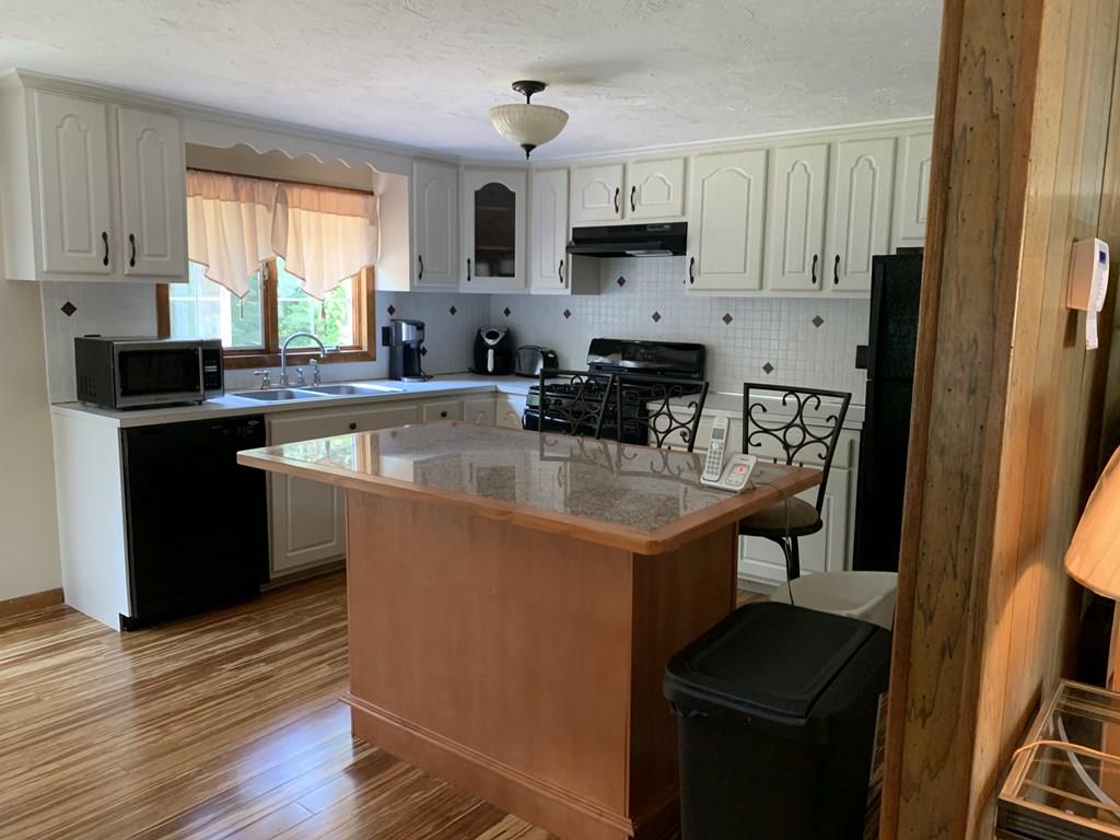 630 Wareham Street Middleboro, MA 02346 - Photo 3 of 10 a kitchen with stainless steel appliances granite countertop a sink a stove a refrigerator cabinets and a window