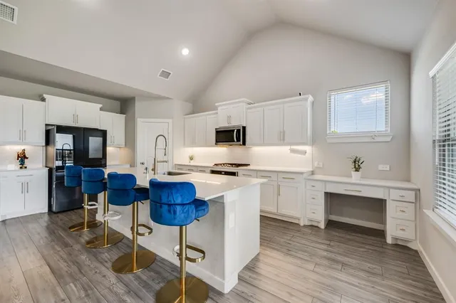 a kitchen with a sink cabinets and wooden floor
