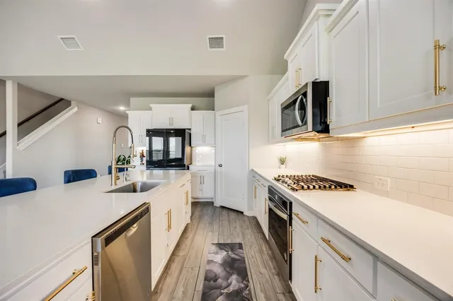 a kitchen with a stove a sink and a microwave