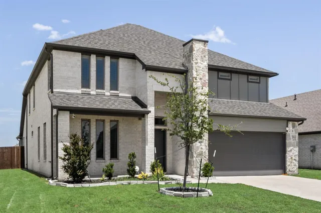 a front view of a house with a yard and garage