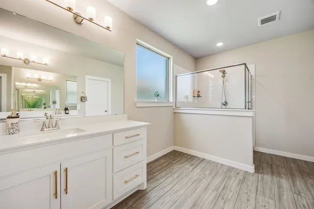 a bathroom with a sink mirror and cabinets