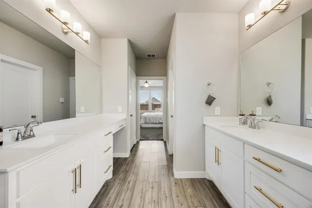 a en suite bathroom with a double vanity sink and mirror