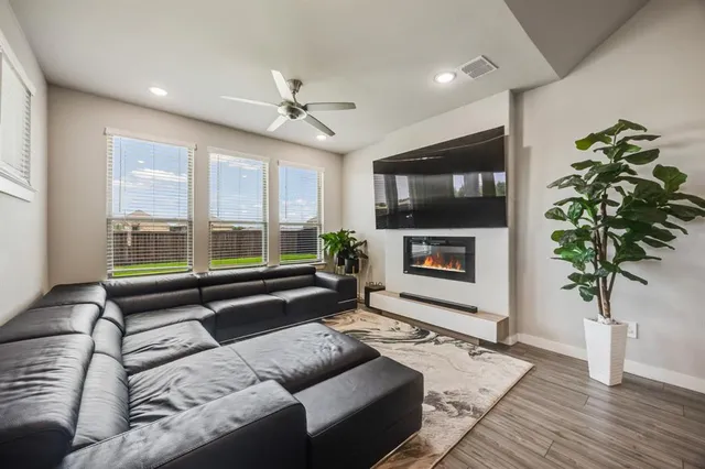 a living room with furniture a flat screen tv and a fireplace