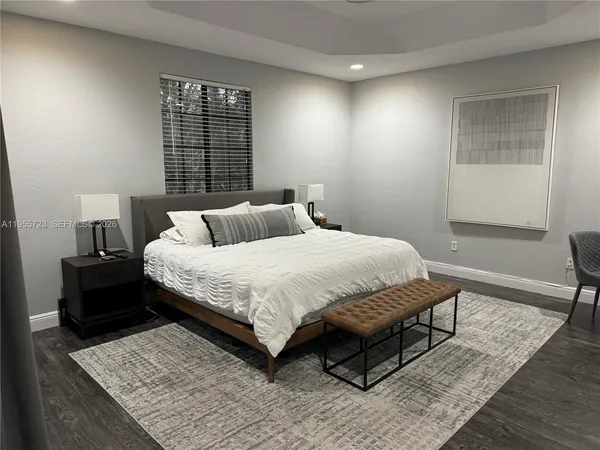 a bedroom with a bed wooden floor and window