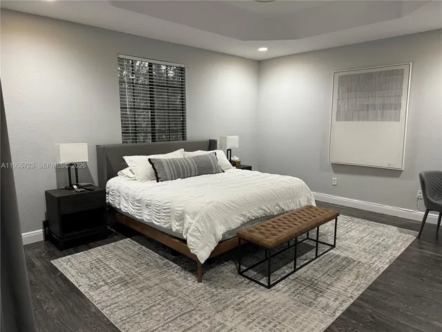 a bedroom with a bed wooden floor and window