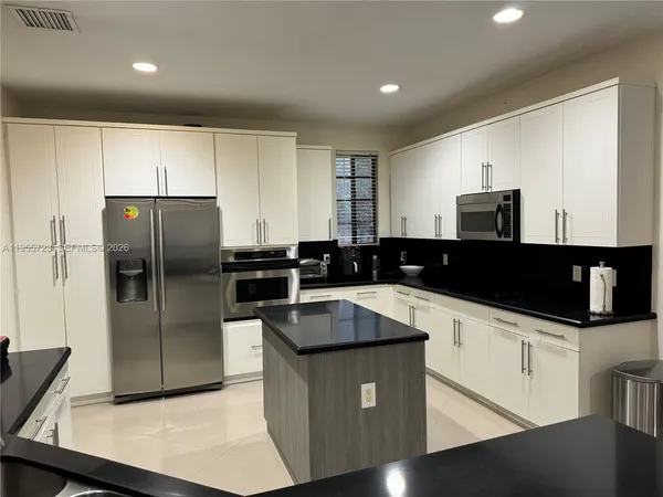 a kitchen with granite countertop a sink and stainless steel appliances