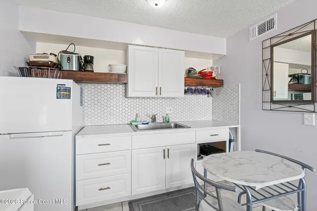 a kitchen with cabinets appliances and furniture